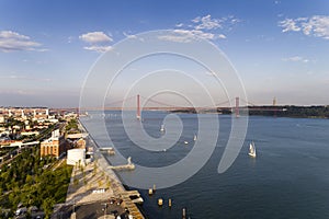 Aerial view of the city of Lisbon with sail boats on the Tagus River Rio Tejo and the 25 of April Bridge on the background;