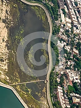 Aerial view of a city neighborhood with shoreline road along a swamp