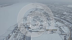 Aerial view of the city residential buildings and a river in winter, urban winter landscape. Clip. Snow covered city in