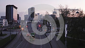 Aerial view of city at sunset, with crossroad and traffic lights. Stock footage. Evening in a modern city with high rise