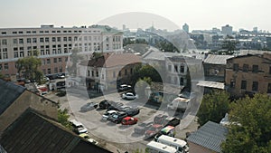 Aerial view of a city yard with ugly facades of houses and many parked cars. Stock footage. Parking located by the