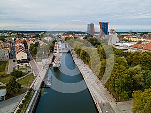 Aerial view of cityscape Klaipeda surrounded by buildings with floating boats on Danes river photo