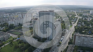 Aerial view of a cityscape and a river far in the distance. Action. Sleeping area, flying over the modern city district