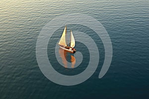 aerial view of classic sailboat gliding on calm sea