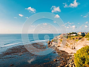 Aerial view of cliff, rocks and ocean at low tide in Bali