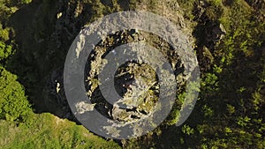 Aerial view of climber solo free climbing on cliffs alone. Man climb the rock without safety harness and ropes. Male