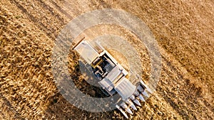 Aerial view, close up details of farmer using combine to harvest crops