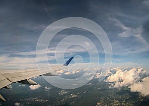 Aerial view of cloud and sky with airplane wing from window