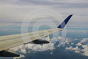 Aerial view of cloud and sky with airplane wing from window
