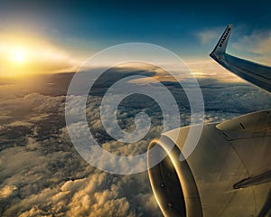 Aerial view of clouds at golden sunset seen from plane window