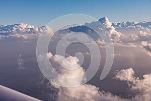 Aerial view of clouds lit by the evening sun over Florida, view from the aircraft during the flight.