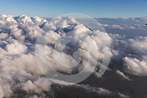 Aerial view of clouds lit by the evening sun over Florida, view from the aircraft during the flight.