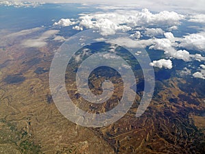 Aerial view of clouds and mountains landscape from an airplane in the stratosphere