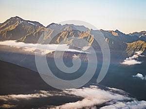 Aerial view of clouds under the mountains during sunset