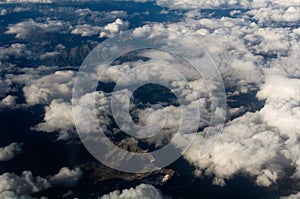 Aerial View of a Cloudscape and mountains below.