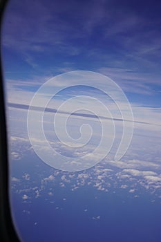 Aerial view on cloudy skies from airplane window