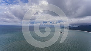 Aerial view with cloudy skies and blue water.