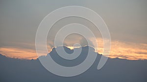 Aerial view of a cloudy sunset while flying above the clouds.