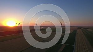 Aerial view of cluster of wind turbines in rural agriculture field.