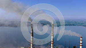 Aerial view of coal power plant high pipes with black smokestack polluting atmosphere.