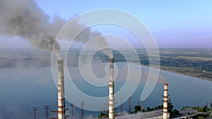 Aerial view of coal power plant high pipes with black smokestack polluting atmosphere. Electricity production