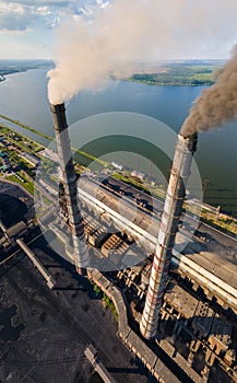 Aerial view of coal power plant high pipes with black smokestack polluting atmosphere. Electricity production with fossil fuel