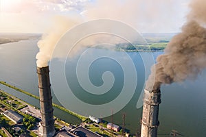 Aerial view of coal power plant high pipes with black smokestack polluting atmosphere. Electricity production with fossil fuel