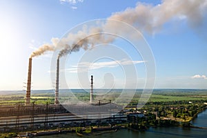 Aerial view of coal power plant high pipes with black smokestack polluting atmosphere. Electricity production with fossil fuel