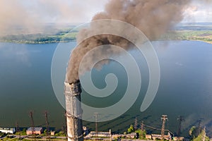 Aerial view of coal power plant high pipes with black smokestack polluting atmosphere. Electricity production with fossil fuel