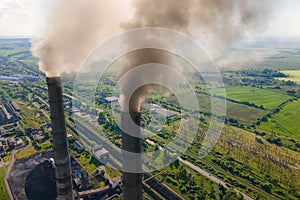 Aerial view of coal power plant high pipes with black smokestack polluting atmosphere. Electricity production with fossil fuel