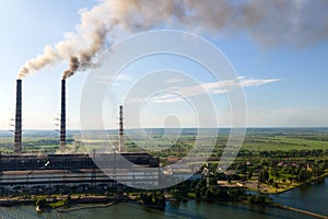 Aerial view of coal power plant high pipes with black smokestack polluting atmosphere. Electricity production with fossil fuel