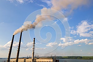 Aerial view of coal power plant high pipes with black smokestack polluting atmosphere. Electricity production with fossil fuel