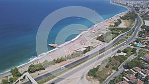 Aerial view of coast and azure ocean with sandy beach. Clip. Alanya, Turkey, flying over the city buildings and long