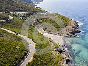 Aerial view of the coast of Corsica, winding roads and coves with crystalline sea. France