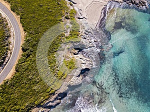 Aerial view of the coast of Corsica, winding roads and coves with crystalline sea. France