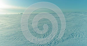 Aerial view of cold winter landscape arctic field, trees covered with frost snow, ice river and sun rays over horizon