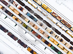 Aerial view of colorful freight train cars on the railway station. Wagons with goods on railroad. Industrial conceptual scene with