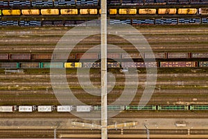 Aerial view of colorful freight trains with goods and bridge on the railway station