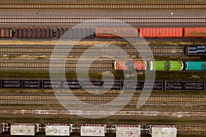 Aerial view of colorful freight trains with goods on the railway station