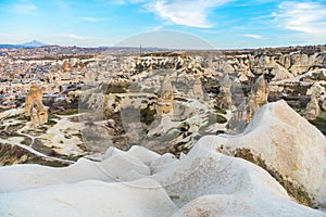 Aerial view of colorful rocks and Cave hotel in the valley of Goreme under sunset, which is built in rock formation in national