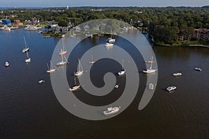 Aerial view of colorful sailboat moorings and docks surrounded by colorful residential rooftops on and azure blue Spa Creek, in hi