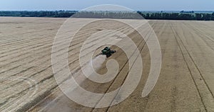 Aerial view on the combines and tractors working on the large wheat field, Harvester on the wheat field, Green harvester