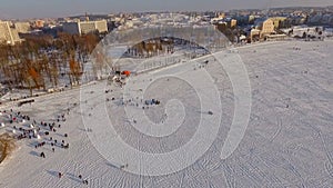 Aerial view. Competitions pilots of the paraglider. Beautiful view of the winter city and the lake from a bird`s-eye