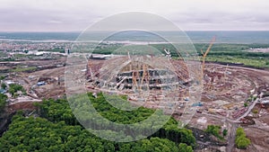 Aerial view on construction area of large modern sporting arena, huge building cranes