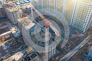 Aerial view of construction cranes and a multi-storey building under construction in a residential area of the city