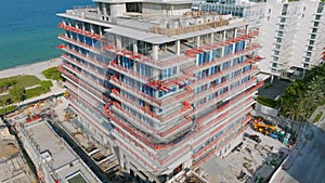 Aerial view of construction of multi-storey buildings near seashore with beautiful summer terrace on rooftop