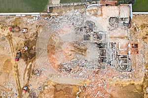 Aerial view of construction site with destroyed industrial building and excavators