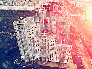 Aerial view of construction site of modern houses or buildings among city architecture, sunlight effect