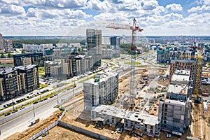 Aerial view of construction site of new residential area with tower cranes