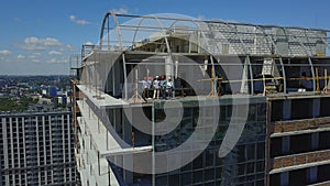 Aerial View Of Construction Site With Team Of Builders On Roof Discussing Plan Of Project